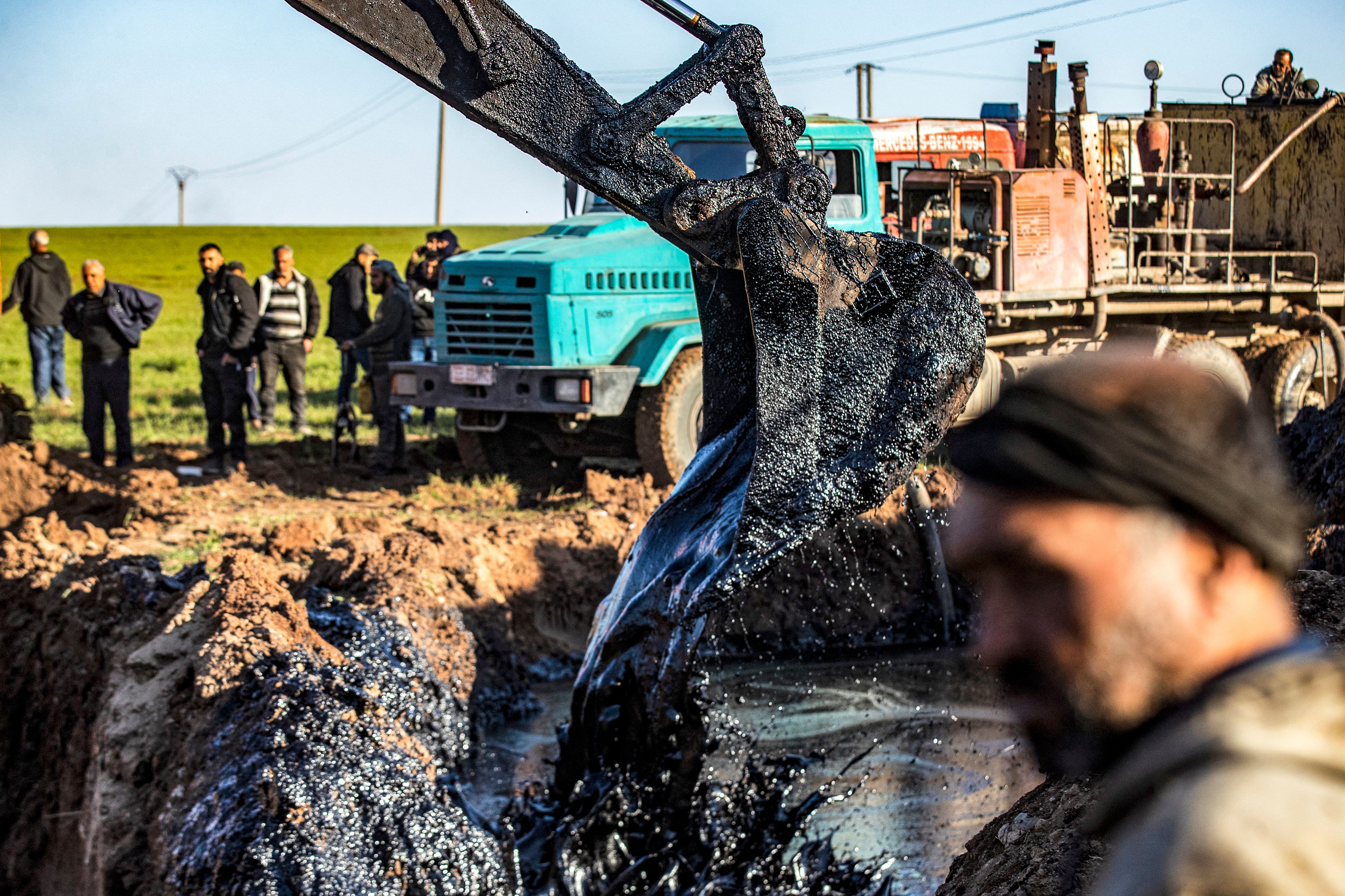 Экскаватор удаляет нефть после аварии на трубопроводе Экскаватор удаляет нефть после аварии на трубопроводе