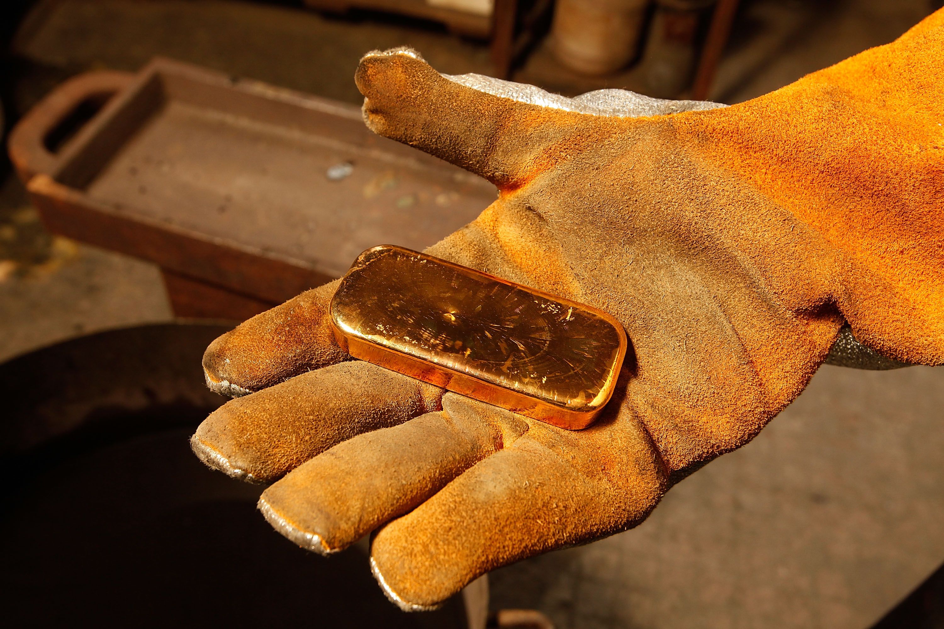 Фрагмент золотого слитка у руці Фрагмент золотого слитка у руці